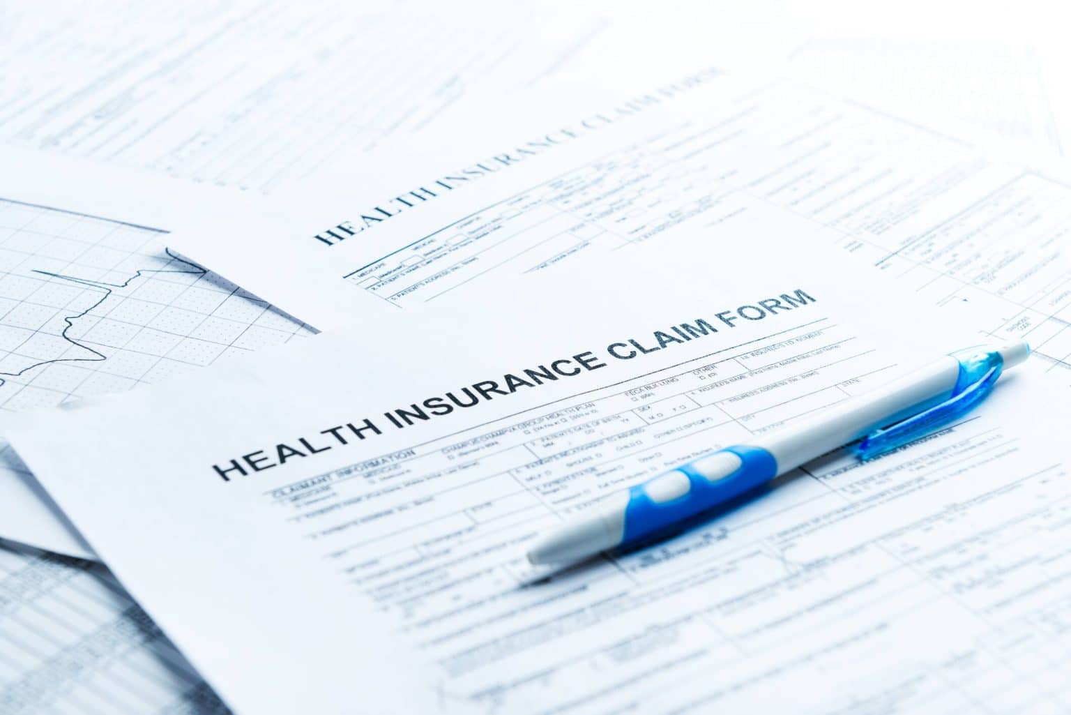 Health insurance claim form with pen on top.