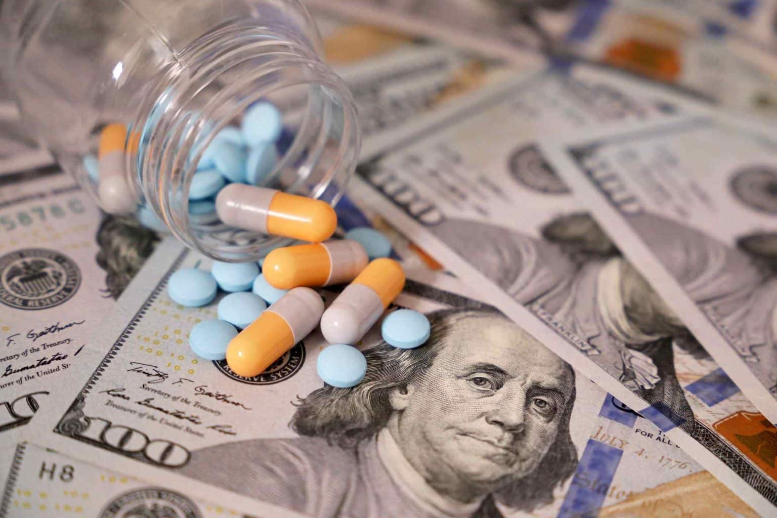 Pills spread across $100 bills