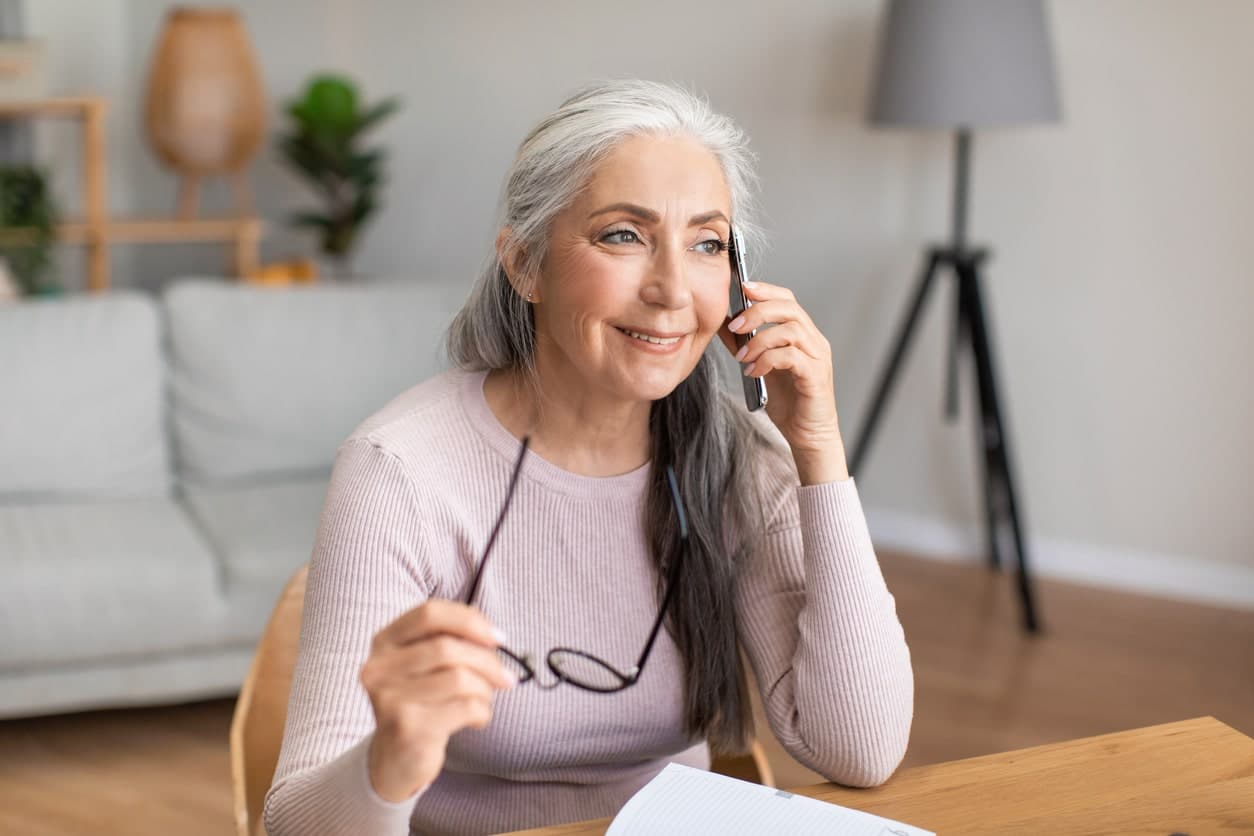 Mature woman enrolling in Medicare over the phone.
